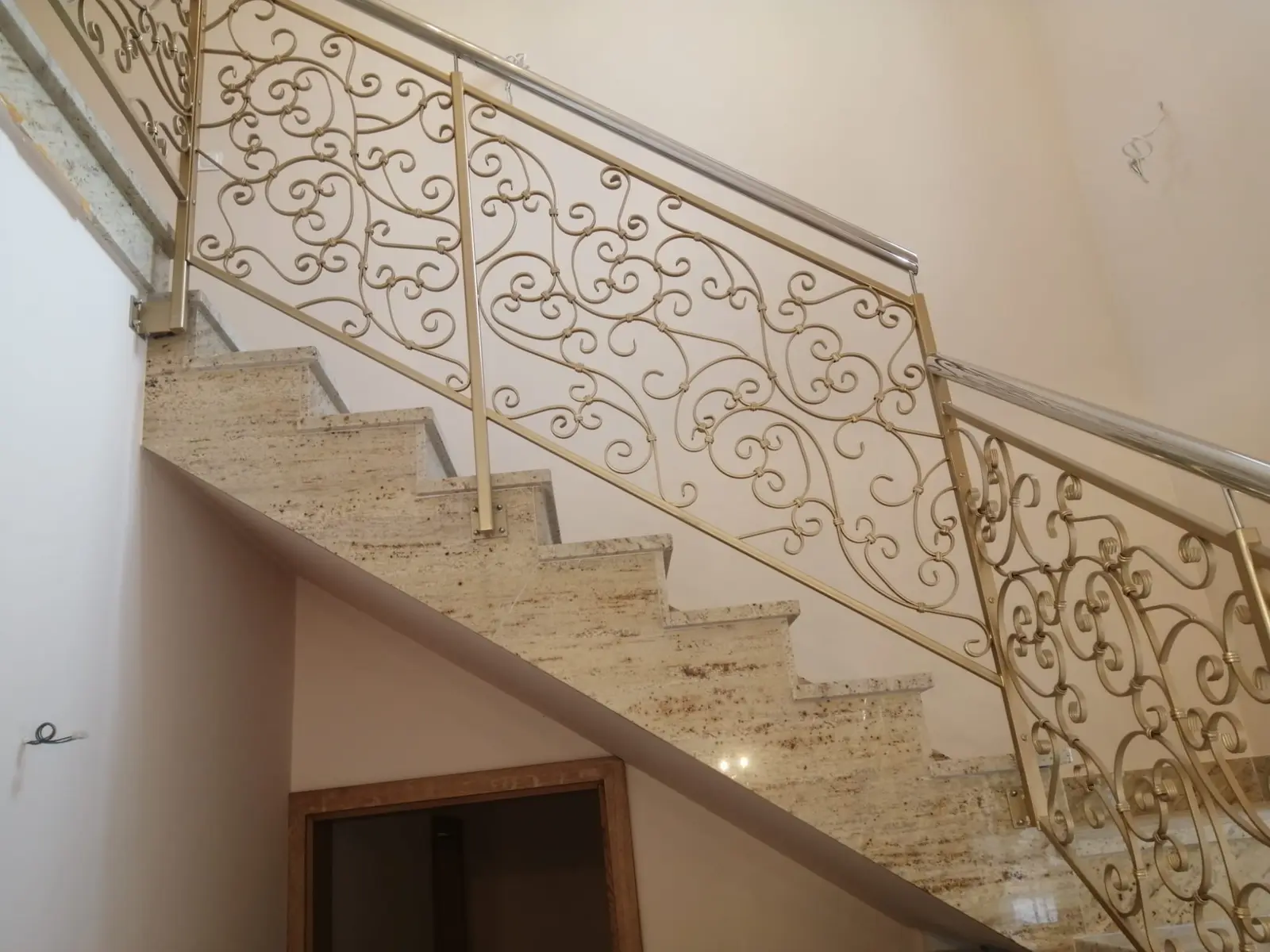 Jasne schody wewnętrzne z dekoracyjną metalową balustradą